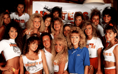 Steve D. deGuzman team at Hooters promotional event, showcasing vibrant 1980s fashion, energetic atmosphere, and team spirit. Perfect for SEO on team photos, 1980s fashion, industry events, and promotional campaigns.